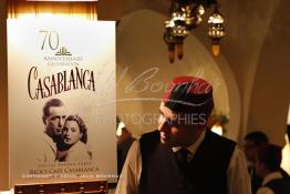 Image du Maroc Professionnelle de  Un serveur du Rick’s Café se penche sur l'affiche annonçant l'hommage du 70e anniversaire au film de 1942 "Casablanca", à Casablanca, au Maroc, le samedi 24 novembre 2012. Une ancienne diplomate américaine a passé deux ans de travaux et un million de dollars en investissements pour amener le Rock’s Café à la plus grande ville du Maroc. La boîte de nuit élégante où Humphrey Bogart se languissait de Ingrid Bergman était juste un jeu sur une scène Warner Bross en Californie, l'équipe du film ne s'est jamais approcher de près de l'Afrique du Nord. (Photo / Abdeljalil Bounhar) 